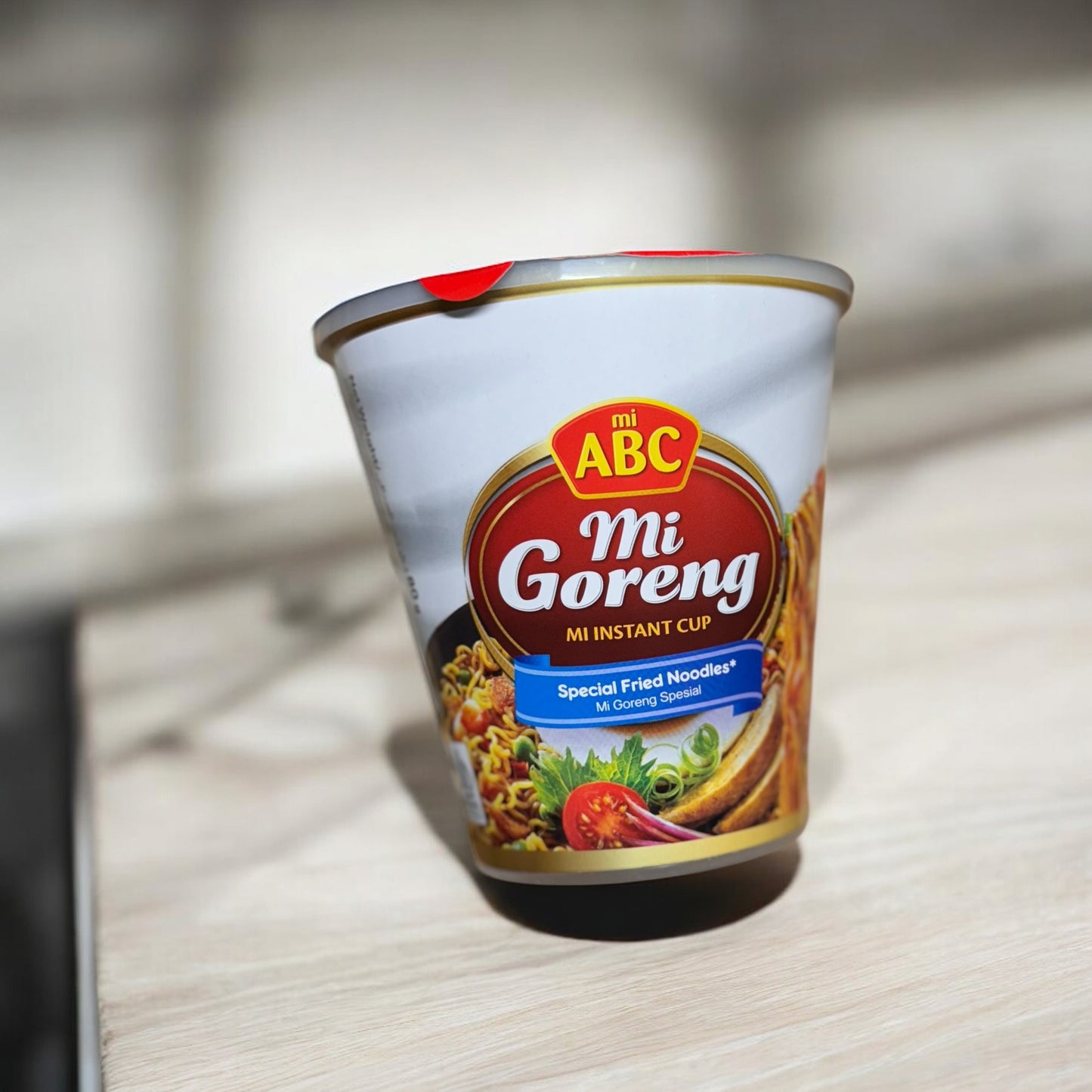 Instant Nudeln der Marke Oriental Merchant, ABC Instant Cup Mie Goreng Spesial in einer weißen Tasse mit Nudeln und Gewürzen.